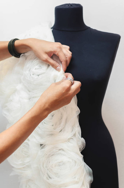 female tailor adjusting garment design on mannequin in workshop - Foto, immagini