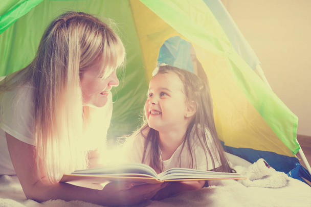 glückliche liebende Familie. hübsche junge Mutter liest ihrer Tochter Buch vor - Foto, Bild