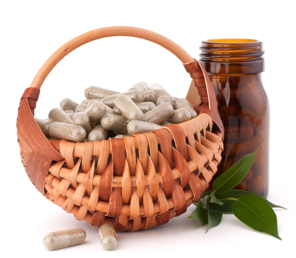 Herbal drug capsules in wicker basket. Alternative medicine conc - Fotoğraf, Görsel