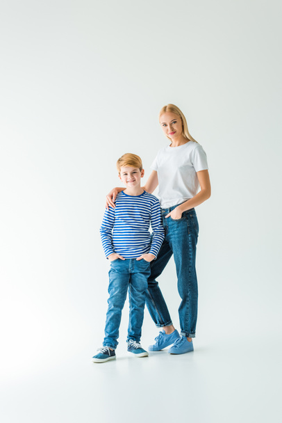 mother in casual clothes hugging son and they looking at camera on white - Foto, Bild