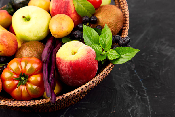Terveellinen värikäs ruokavalikoima: hedelmät, vihannekset, superruoka, lehti korissa tummalla pohjalla. Puhdasta ruokaa. Vegaani. Vieroitushoitoa. Supermarkettien tuote. Valikoima Tuore Organic. Luonnollinen käsite
  - Valokuva, kuva