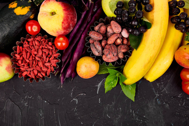 Selección de alimentos coloridos saludables: frutas, verduras, semillas, superalimentos, frijoles, vegetales de hoja sobre fondo oscuro. Comer limpio. Vegano. Desintoxicación. Surtido de productos de supermercado Fresh Organic Natural Concept
  - Foto, Imagen