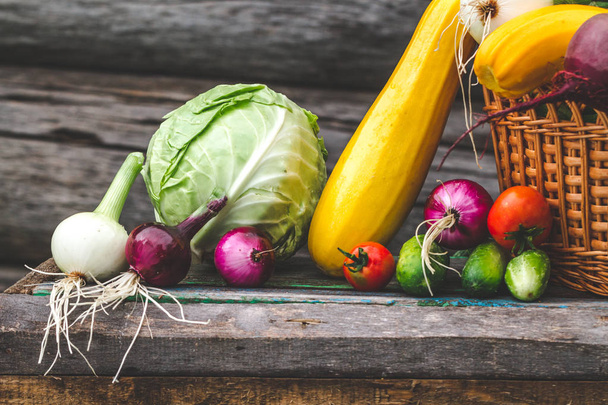 Food composition of fresh vegetables in basket on wooden background. Healthy food concept. - Fotografie, Obrázek