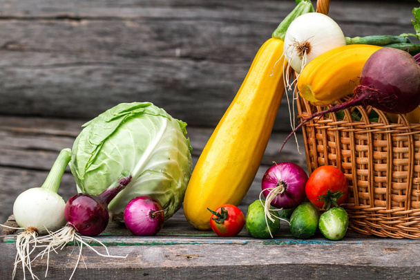 Food composition of fresh vegetables in basket on wooden background. Healthy food concept. - Fotografie, Obrázek