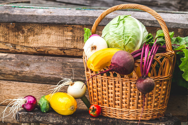 Still life of fresh vegetables in basket on wooden background. Vitamins. Healthy food. - Fotografie, Obrázek