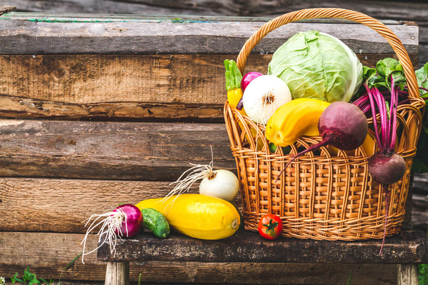 Still life of fresh vegetables in basket on wooden background. Vitamins. Healthy food. - Valokuva, kuva