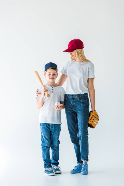 mother and son holding baseball equipment on white - Photo, Image