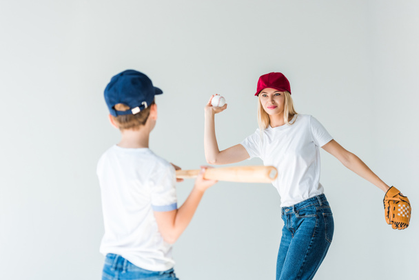 attrayant mère tangage balle de baseball à son fils avec batte de baseball isolé sur blanc
 - Photo, image