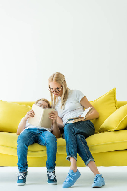 livre de lecture mère et fils sur canapé jaune sur blanc
 - Photo, image