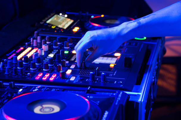 DJ mixing tracks on a mixer in a nightclub - Photo, Image
