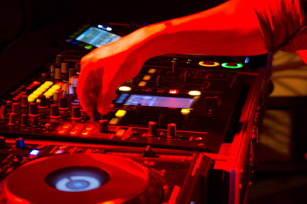 DJ mixing tracks on a mixer in a nightclub - Фото, зображення