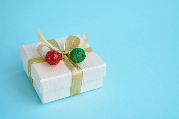 White gift or present boh with Christmas decoration on blue background. Copy space. Christmas greeting card.  - 写真・画像