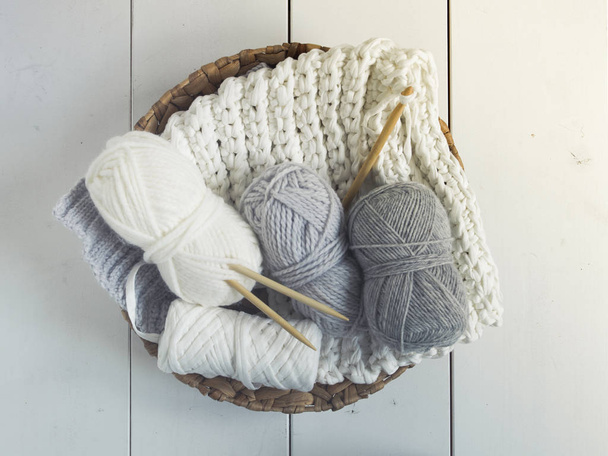 Pastel wool threads in wicker basket on white floor - Zdjęcie, obraz