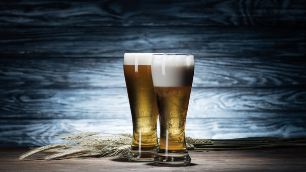 fresh beer in glasses and wheat spikelets on wooden table, oktoberfest concept - Photo, image
