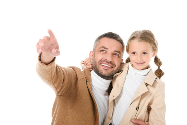 χαμογελαστός ο πατέρας δείχνει κάτι για την κόρη στο Φθινοπωρινό ντύσιμο, απομονώνονται σε λευκό - Φωτογραφία, εικόνα