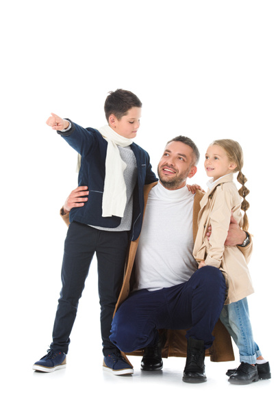 onnellinen isä halaamassa lapsia syksyn asussa, poika näyttää jotain eristettyä valkoisella
 - Valokuva, kuva