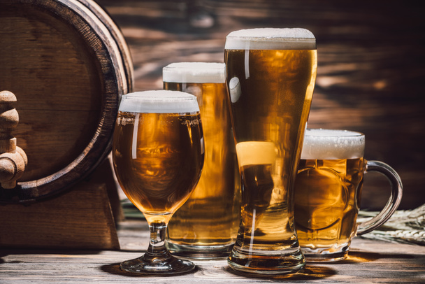 golden beer in glasses and beer barrel on wooden table, oktoberfest concept - Фото, изображение