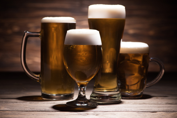 four glasses of tasty beer on wooden tabletop, oktoberfest concept - Photo, image