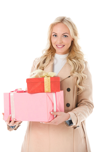 happy woman in beige autumn coat holding presents, isolated on white - Fotó, kép