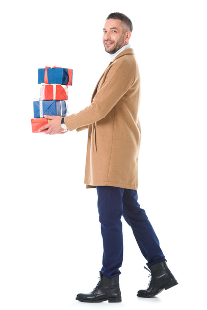 stylish man in beige coat holding gift boxes, isolated on white - Foto, afbeelding