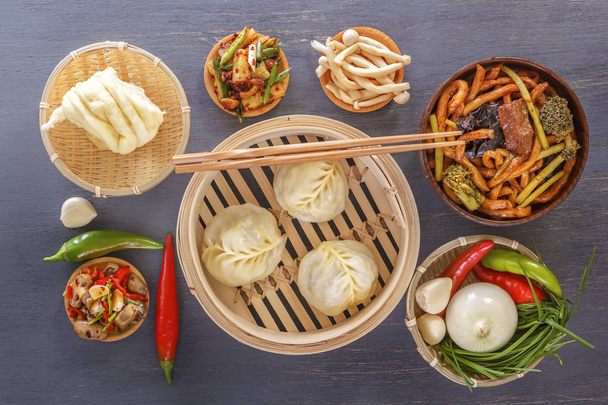 Traditional snacks of Chinese cuisine dim sum - dumplings, spicy salads, vegetables, noodles, steam bread. Top view. - Photo, Image