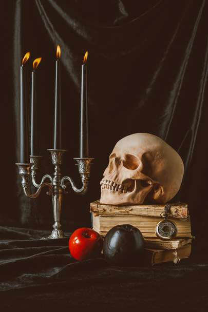 halloween decorations and skull on ancient books on black cloth - Fotó, kép