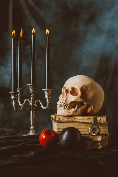 улаштування, череп Хеллоуїн, стародавні книги з чорні та червоні яблука на чорний Серветка з диму - Фото, зображення