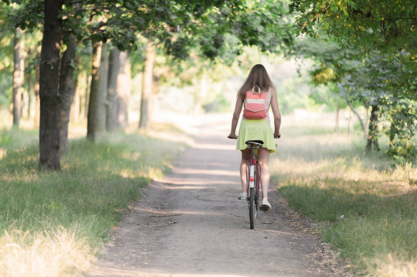 Güzel spor kız parkta bir yürüyüşe retro bisikletle. - Fotoğraf, Görsel