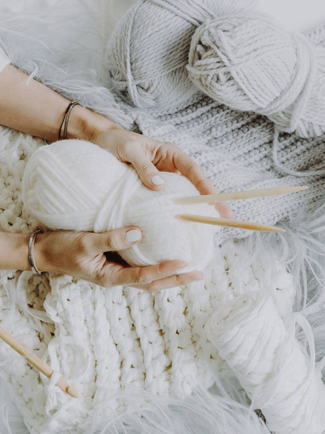 Detail view of female hands holding threads on knitting background - Фото, зображення