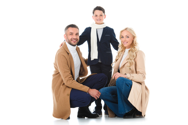 glückliche Familie beim Umarmen mit Sohn im Herbst-Outfit, isoliert auf weiß - Foto, Bild