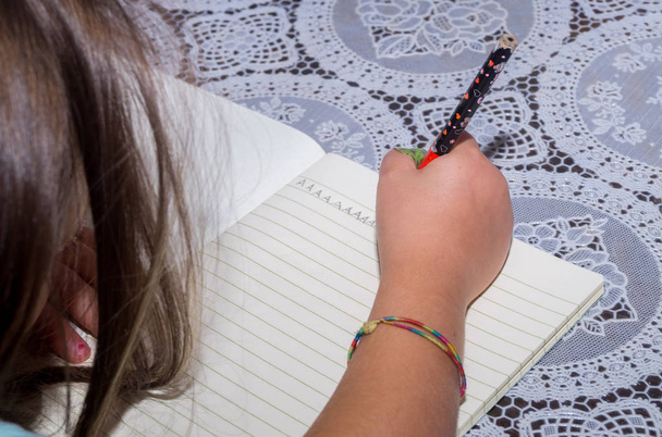 schoolmeisje schrijft huiswerk in de beurt - Foto, afbeelding