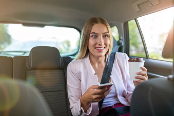 Mujer con teléfono inteligente en un coche
 - Foto, imagen