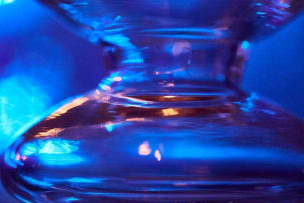 Ampoule en verre sur fond bleu. Photo abstraite du verre
. - Photo, image