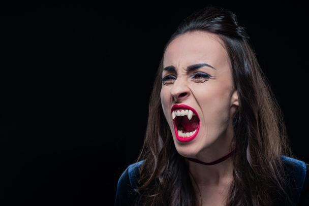 dreadful woman showing vampire teeth isolated on black - 写真・画像