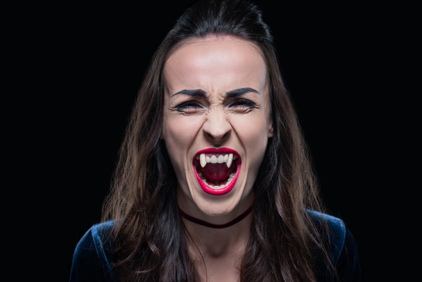 gothic woman showing vampire teeth isolated on black - Foto, Imagem