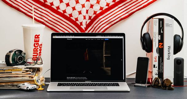 Londýn, Velká Británie - 13 září 2018: Kreativní stůl s prohlížečem Safari na notebooku Macbook Pro nabízí Apple počítače webové stránky nejnovější iphone Xs smartphone s bučení bujný podrobněji v režimu focení - Fotografie, Obrázek