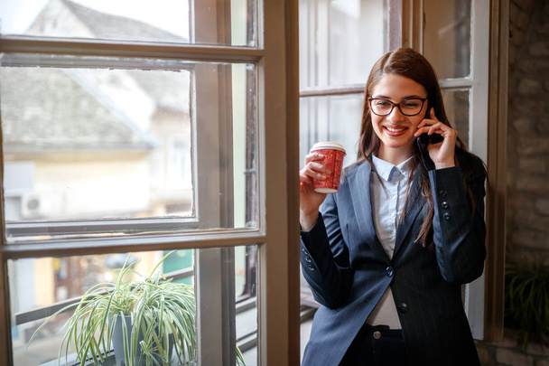 Smiling business girl in office talking on cell phone  - Foto, immagini