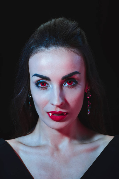 szexi vámpír nő nézett elszigetelt fekete fényképezőgép piros szemmel - Fotó, kép