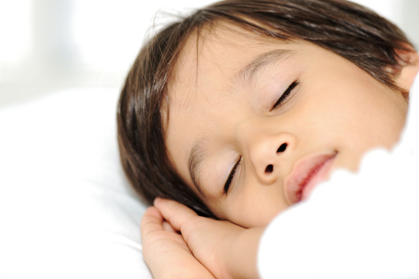 Kid on sleeping bed, happy bedtime in white bedroom - Foto, afbeelding