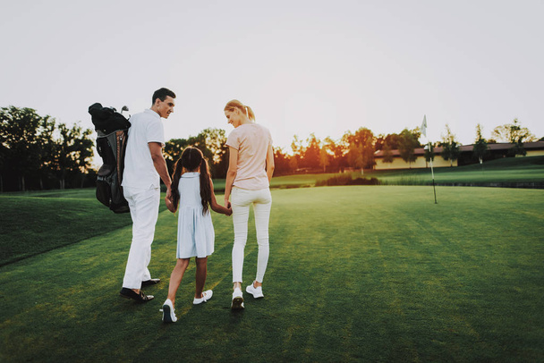Happy Young Family Relax on Golf Field in Summer. Relaxing in Golf Club. Sports in Summer. Outdoor Fun in Summer. Family Fun. Healthy Lifestyle Concept. Little Girl. Green Grass. - Photo, image
