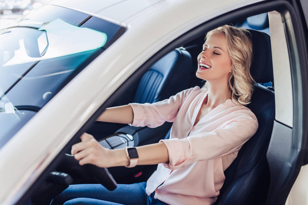 portrait of happy woman sitting in the car in dealership salon - Photo, Image