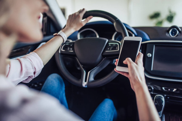 close up view of woman sitting in the car using smartphone - Photo, Image