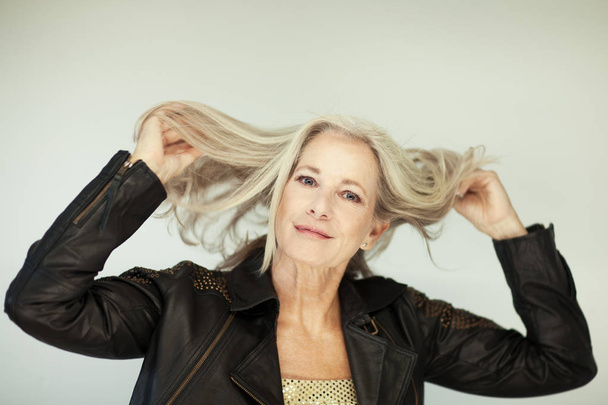 stunning beautiful and self confident best aged woman with grey hair smiling into camera, portrait with white background - 写真・画像