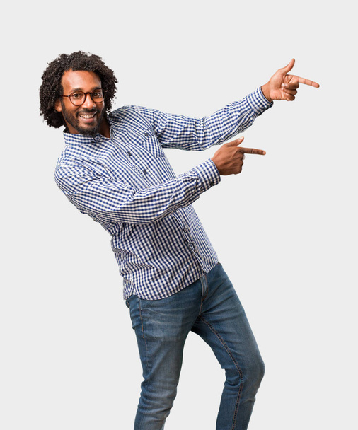 Handsome business african american man pointing to the side, smiling surprised presenting something, natural and casual - Фото, зображення