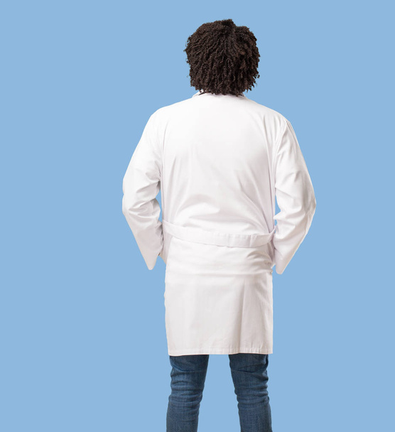 Handsome african american medical doctor showing back, posing and waiting, looking back - Photo, Image