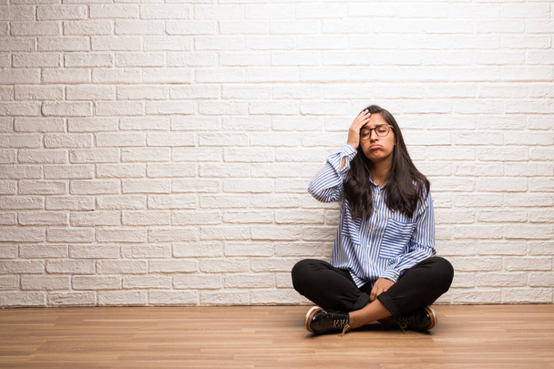 Nuori intialainen nainen istuu seinää vasten huolissaan ja hukkua, unohtumaton, ymmärtää jotain, ilmaus shokki tehtyään virheen
 - Valokuva, kuva