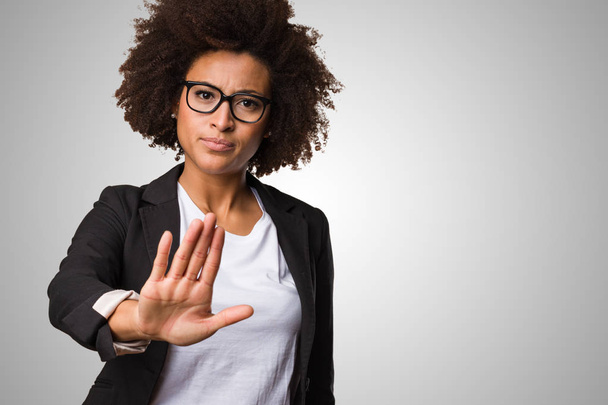 black business woman doing stop gesture on gray background - Photo, Image