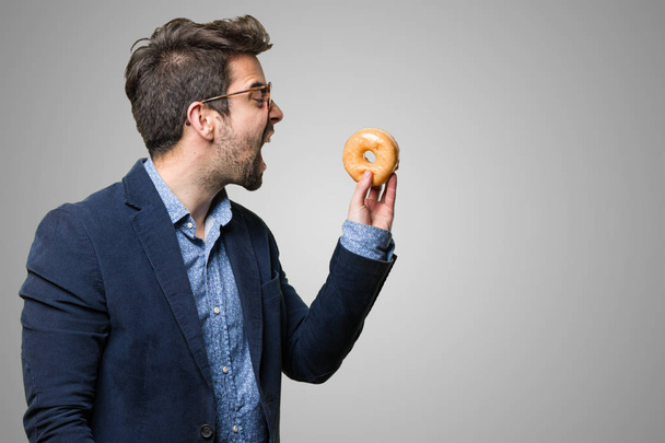 hombre de negocios sosteniendo un donut aislado sobre fondo blanco
 - Foto, Imagen