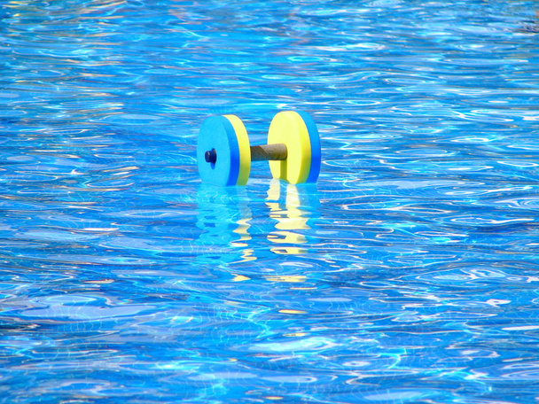 Mancuerna de aeróbic acuático flotante en piscina
 - Foto, imagen