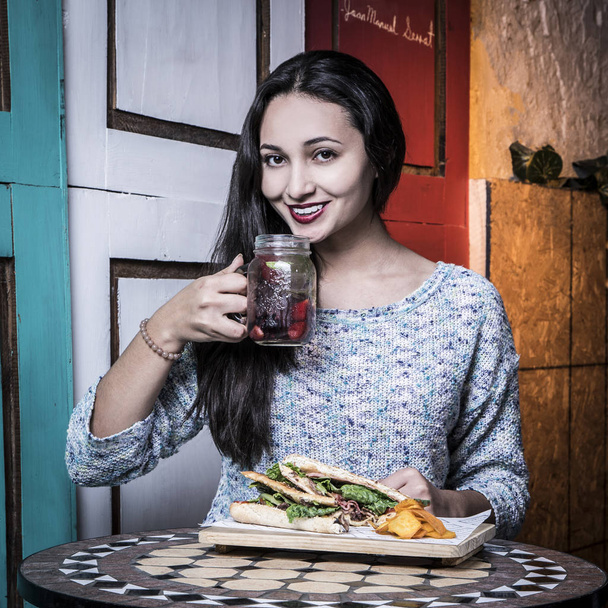 Beautiful woman with smile, eating at old restaurants - Фото, изображение